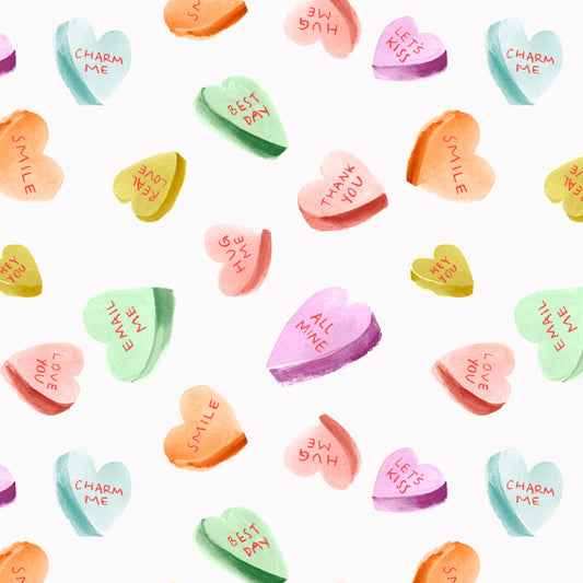 A collection of colorful heart-shaped candies with various messages printed on them, displayed on a white background.